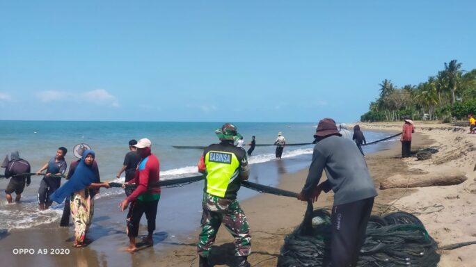 Bantu Tarik Pukat Ikan, Babinsa Posramil Simpang Mamplam Ingatkan Nelayan Jaga Kelestarian Laut
