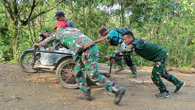 Kesigapan Anggota Satgas TMMD Reguler Ke 120 Kodim 0105/Abar Bantu Warga Melintasi Jalan Sasaran Fisik TMMD