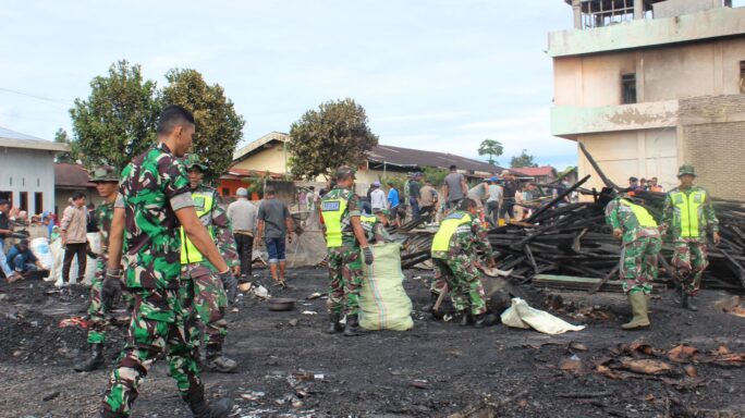 Personel Yonif 114/SM Bersama Masyarakat Desa Binaan Bantu Bersihkan Sisa Kebakaran di Kampung Bahgie Bertona.