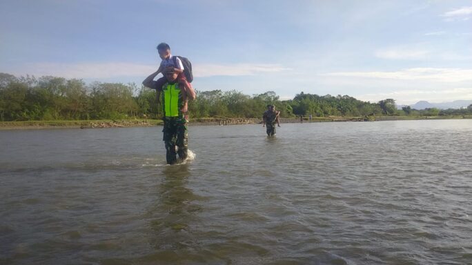 Aksi Heroik Babinsa Posramil 12/Panton Reu Panggul Siswa SD Seberangi Sungai