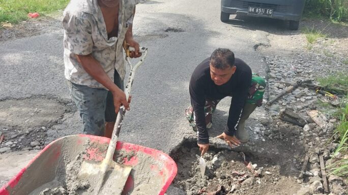 Babinsa Posramil Darul Hasanah Perbaiki Dan Tambal Jalan Rusak Berlubang.