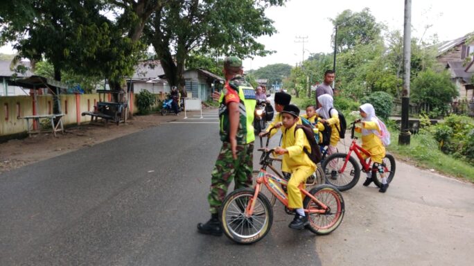 Babinsa Koramil 08/Rantau Bantu Sebrangkan Jalan Siswa SD Ke Sekolah