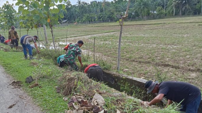 Cegah Genangan Air, Babinsa dan Warga Bersatu Gotong Royong Bersihkan Parit