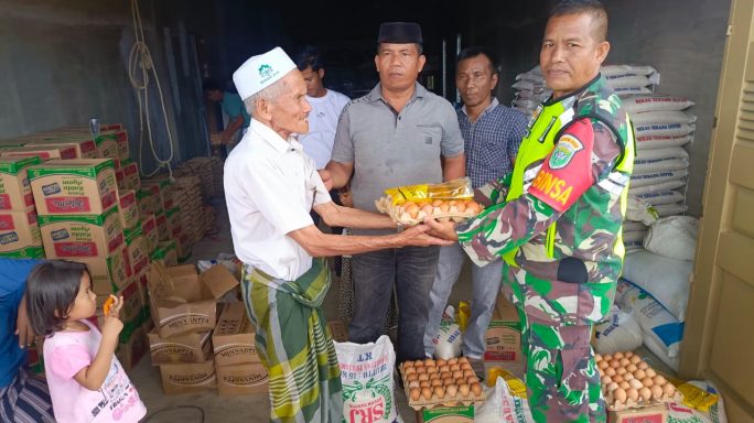 Babinsa Dampingi Penyaluran Bansos Kepada Warga Pasca Banjir Yang lalu.