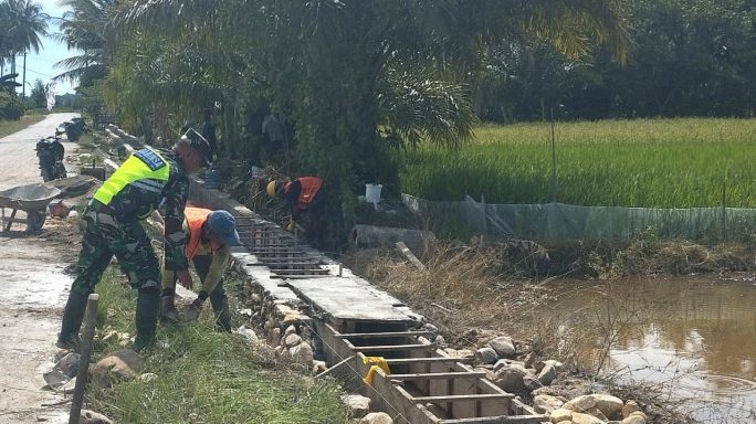 Wujud Kebersamaan, Babinsa Koramil 09/Banda Mulia Gotong Royong Bersama Masyarakat Dalam Pembuatan Saluran Irigasi