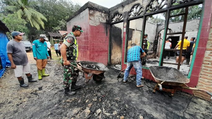 Koptu Basuki Bantu membersikan puing-puing Korban Rumah Kebakaran di Desa Suka Makmur