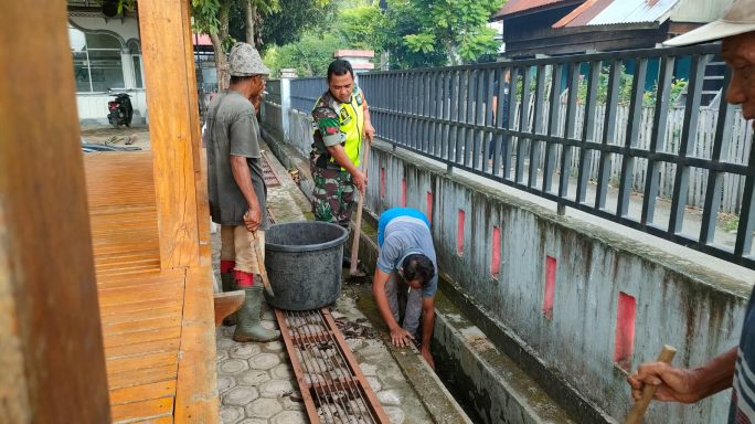 Babinsa Koramil 11/Bandar Baru bersama warga dengan penuh semangat membersihkan selokan.