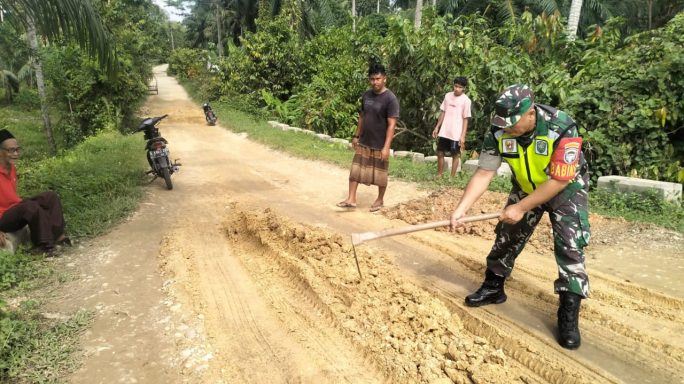 Tumpukan Tanah Licin, Serda Joni Siregar Bantu Warga Desa Bukit Tukuh Demi Keselamatan Pengguna Jalan”