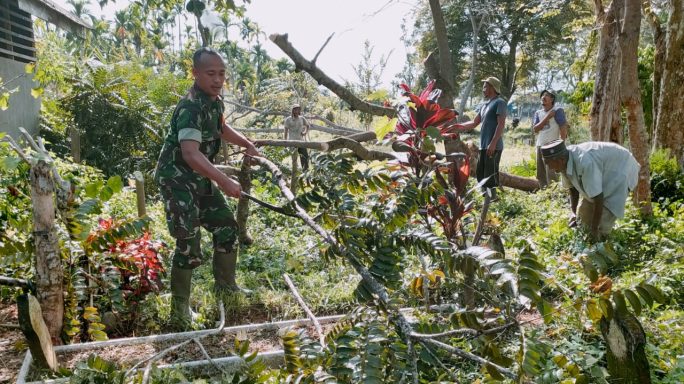 Tingkatkan Kebersihan, Sertu Arisandi dan Masyarakat Bersihkan Ranting Pohon dan Rumput Liar di TPU