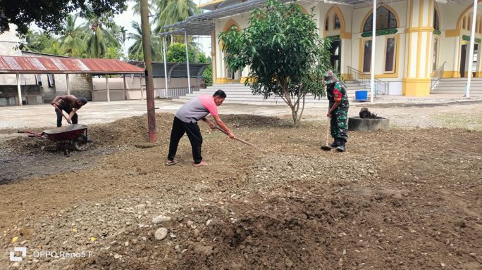 Babinsa Bersama Warga Gotong Royong Ratakan Tanah Timbun Batu di Halaman Masjid