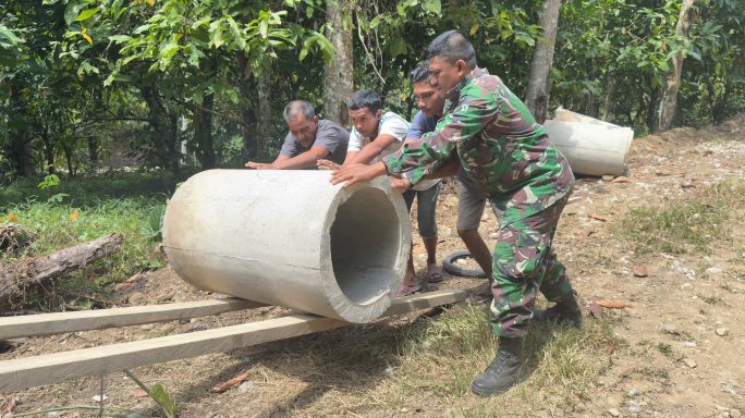 Warga dan Satgas TMMD Bahu-Membahu Turunkan Gorong-Gorong: Bukti Kemanunggalan TNI dan Rakyat.