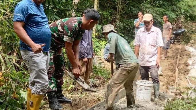 Babinsa Bantu Warga Cor Jalan Rabat Beton Desa Binaan