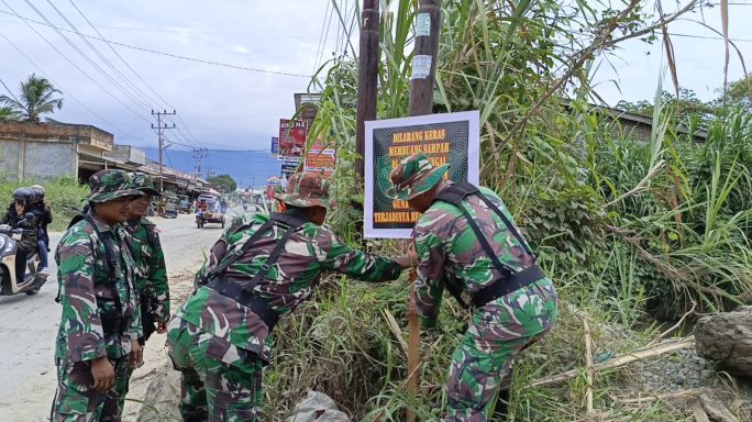 Babinsa Pasang Spanduk Larangan Jangan Buang Sampah ke Sungai