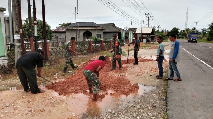 Sinergi TNI-Rakyat: Cegah Genangan Air, Babinsa Gotong Royong Timbun Lubang