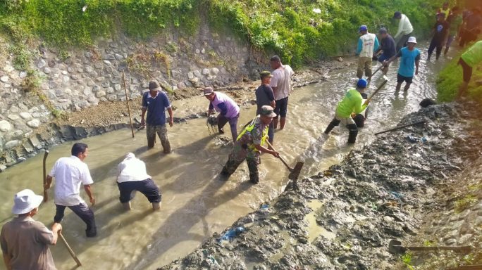 Dukung Kelancaran Pengairan dan Ketahanan Pangan, Babinsa Koramil 14/Mila, Kodim 0102/Pidie Bersama Warga Bersihkan Saluran Irigasi Persawahan