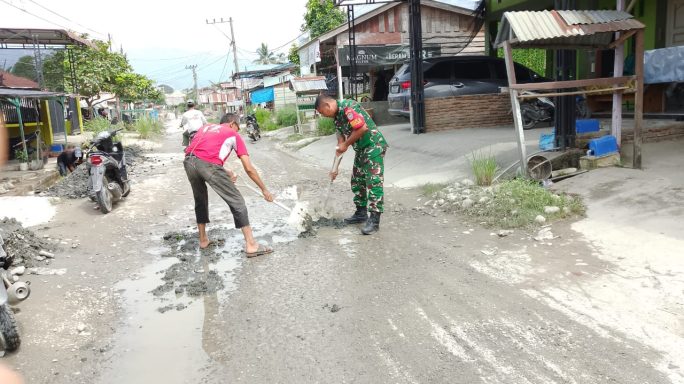 Babinsa Bersama Warga Masyarakat Gotong Royong Timbun Jalan Berlubang di Desa Binaan