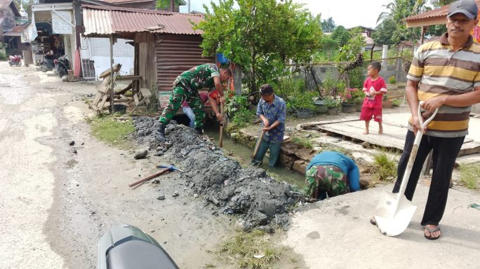 Babinsa Kerja Bhakti Bersama Warga Bersihkan Parit di Desa Kutambaru Bencawan