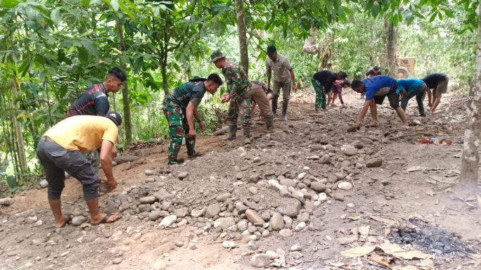 Satgas TMMD Bersama Dengan Warga Masyarakat Ratakan Jalan Dengan Kerikil
