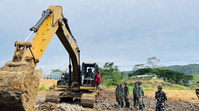 Personel Kompi Zeni Yonif TP-857/GG dengan masyarakat dalam pelatihan pengenalan dan cara mengoperasionalkan alat berat Exavator