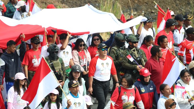 KIRAB MERAH PUTIH, SATGAS YONIF 112/DJ ARAK DAN BENTANGKAN BENDERA RAKSASA DI PUNCAK JAYA